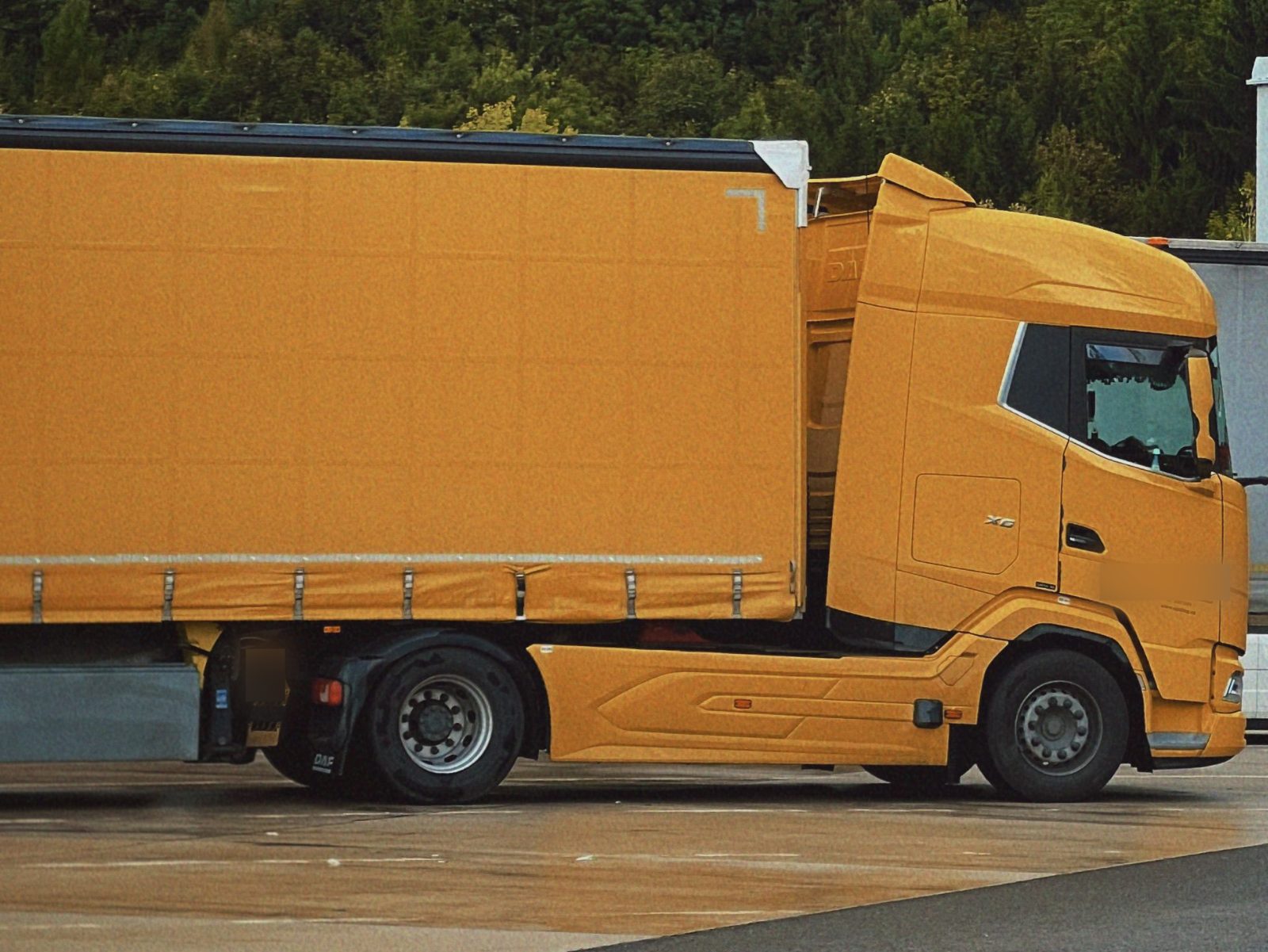 DAF tractor unit with a curtainsider trailer in a parking lot